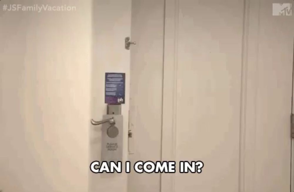 a woman wearing sunglasses is peeking out of a door and says `` can i come in ? ''