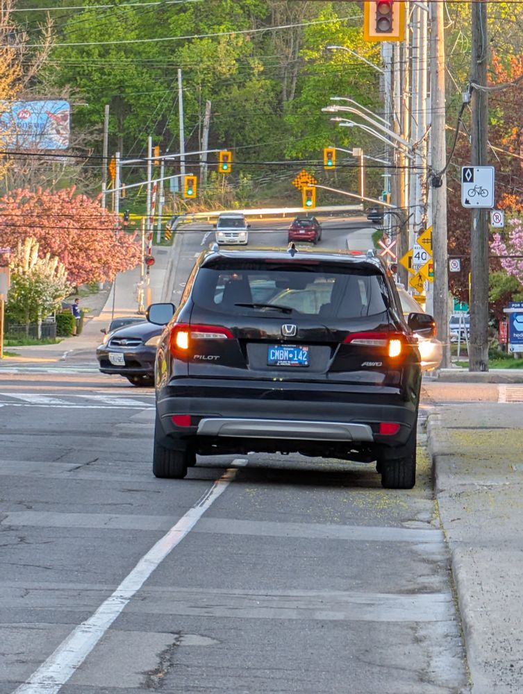 Dickhead parked with the famous "I can stop anywhere I like" 4 ways. Chef's kiss is the bike sign directly to the right of the asshole.