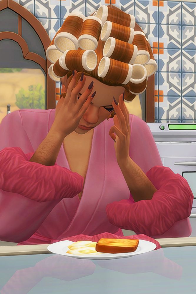 The Sims 4 screenshot of a female sim in a pink robe and hair curlers grumpily rubbing her temples while she eats her breakfast