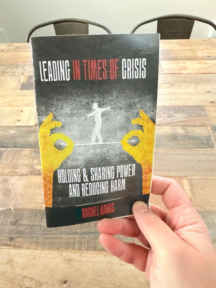 my friend Nate holds a copy of my zine Leading in Times of Crisis