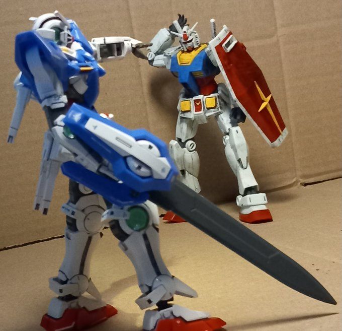 Confrontation between the Exia and the RX-78-2. The Exia can be seen pointing at their opponent while the RX-78-2 tries to draw its beam saber from their backpack.