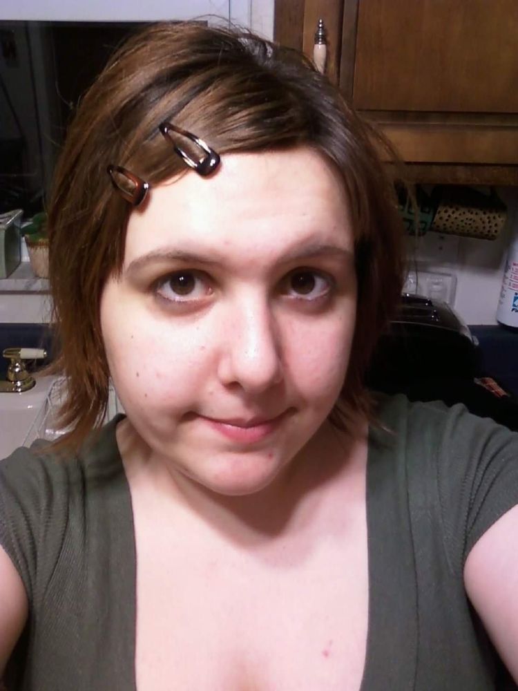 Image of a young woman with short hair and longer bangs. Her hair is parted heavily to one side and held back with two hair clips.