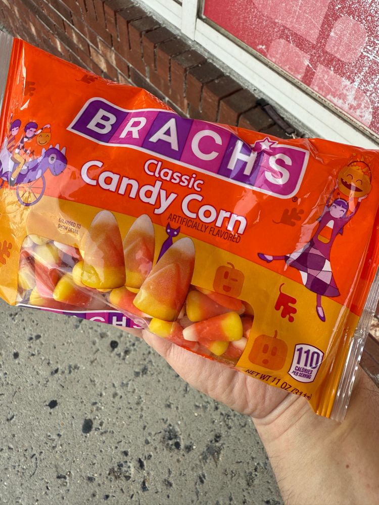 My hand holding a bag of Brach’s candy corn