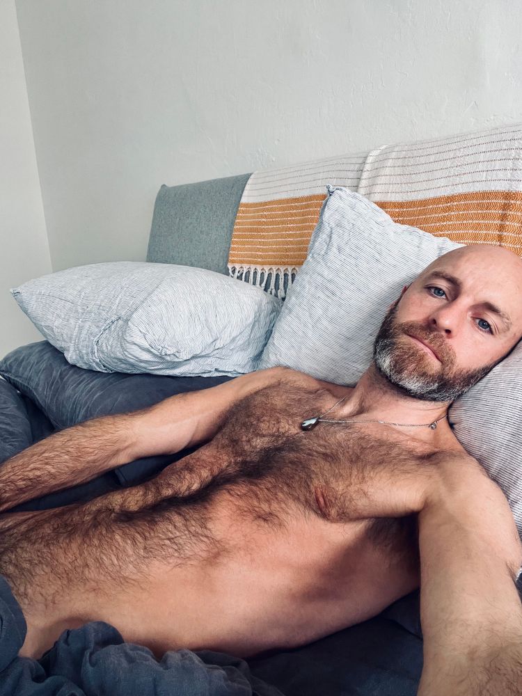 Hairy man laying in bed 