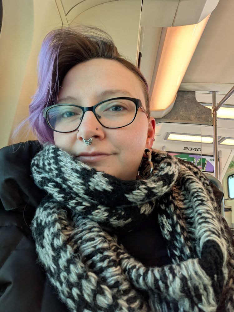 Purple haired person with glasses 