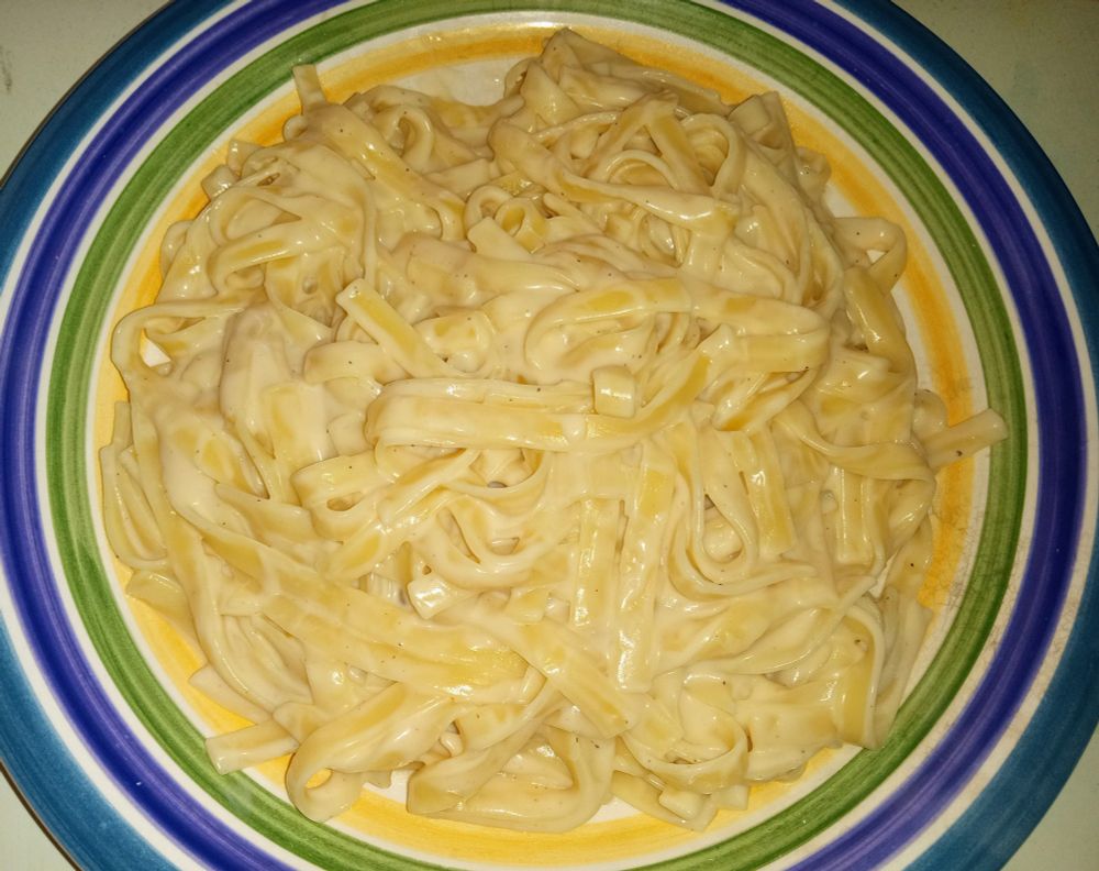 A plate of fettuccine alfredo noodles.