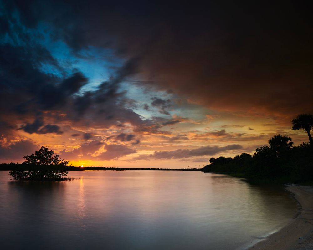 A long exposure of a bay near Marineland, FL. The camera is facing west and catching the last few seconds of the day's sun. The water is a hazy translucent mirror from the long exposure. Nikon D850