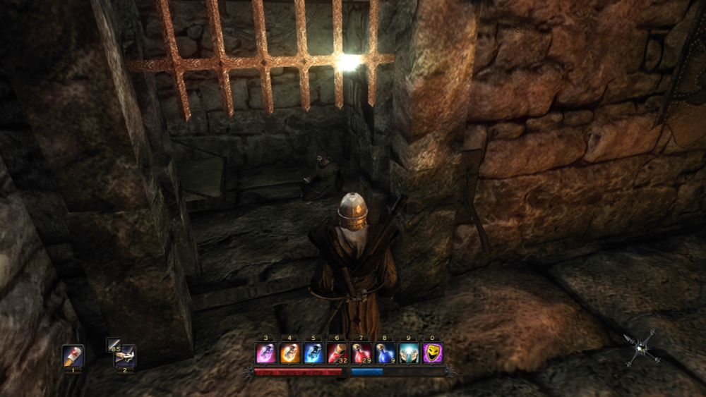 Image de Risen, on y voit le personnage principal dans une ruine, prêt à passer une herse derrière laquelle un personnage est assis dans une prison en train de se fumer un énorme BEDO !