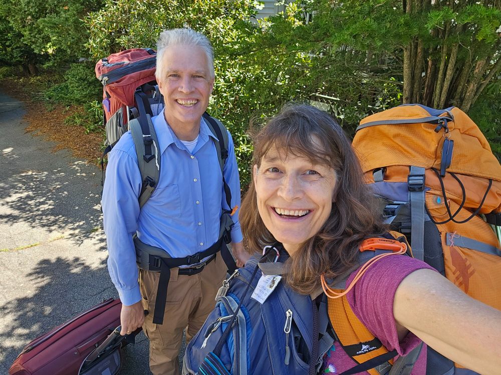 Middle aged couple loaded with business luggage and backpacking gear leaving their home in Massachusetts.