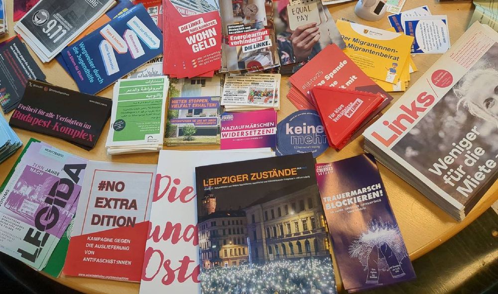 Foto eines Flyer und Infotisches im linxxnet, auf dem unter anderem die neue Broschüre "Leipziger Zustände" zu sehen ist.