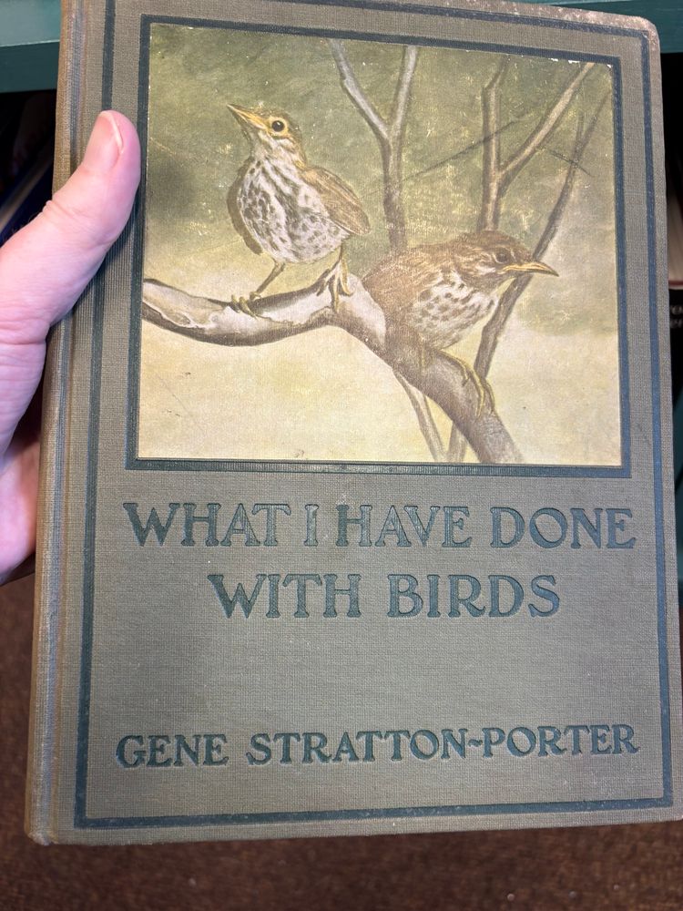 a book called “what I have done with birds” by gene stratton-porter. the image on he cover is two brownish birds on a tree