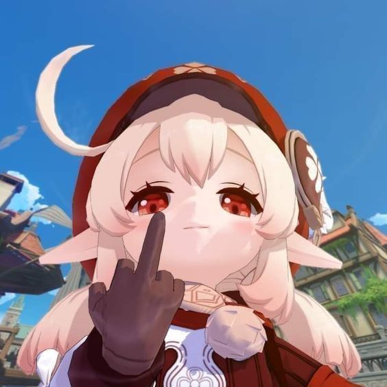 The image of Klee, a Genshin Impact character, with elf-like ears, light blonde hair, and large red eyes. She wears a red hat with a floral emblem on the side and a matching red outfit. Her hand is prominently raised in the center of the image, with the middle finger extended in a gesture. The background depicts a bustling town scene with clear blue skies and buildings that look like a European architectural style, with pointed rooftops and decorative facades.

The image is used to directly be a message to racist white people and Trump supporters by Aveta making it clear it's an explicit fuck you to them.