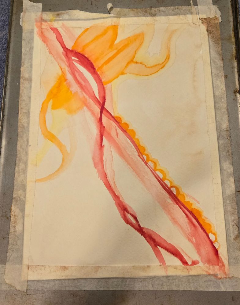 This is the beginning of a watercolor painting. Here we have some red wavy lines in the middle, at varying degrees of light or dark. There's some orange on the upper side of the paper; it looks a bit like leaves. Not sure what it actually is though. The background of the picture has a light brown (also called sepia) tint to it.