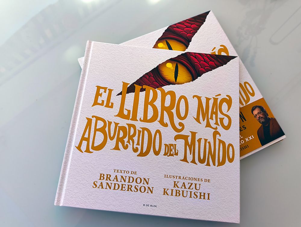 Dos ejemplares de «El libro más aburrido del mundo», grandes, finos y cuadrados, el de arriba sin faja y el de abajo con. La cubierta es blanca y con el título y los autores (Brandon Sanderson y Kazu Kibuishi) en tonos dorados. Una raja en la parte superior de la cubierta deja ver escamas rojas y un ojo malvado de dragón.

(Describo la faja en la siguiente foto).
