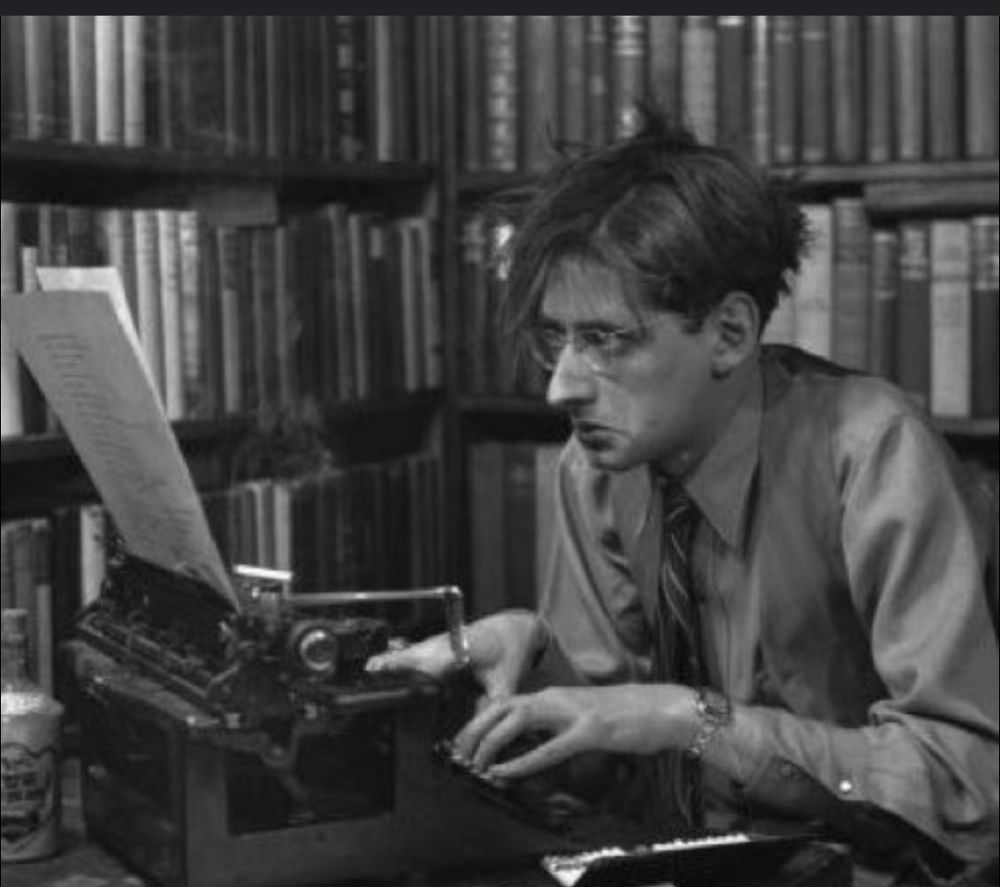 Photograph of author Robert Bloch, at his typewriter.