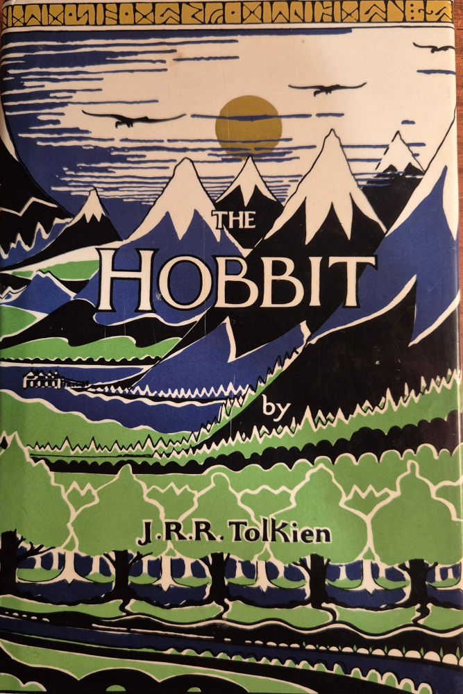 Cover of The Hobbit, showing a landscape with trees and snow-covered mountains in the distance.