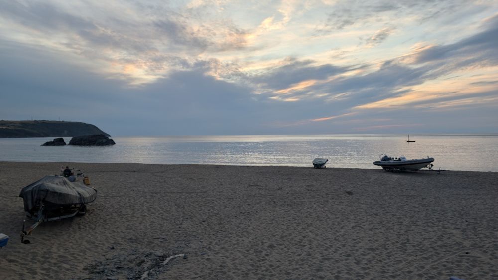 A photo of the sunset at Tresaith beach on 13th July 2025. There's a low cloud blocking where the sun should be.