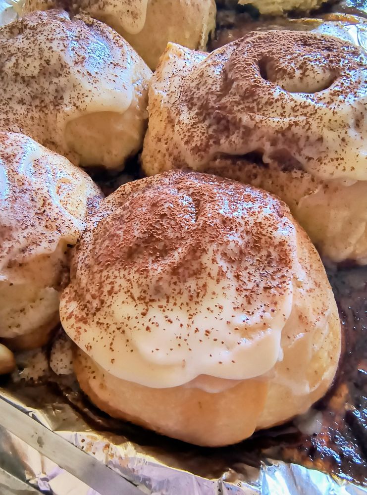 Cinnamon rolls covered in mascarpone icing and dusted in cocoa powder 