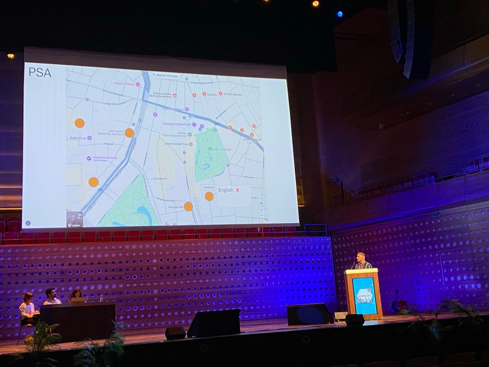 A scientist with a cool haircut shows a map of barber shops in Antwerp