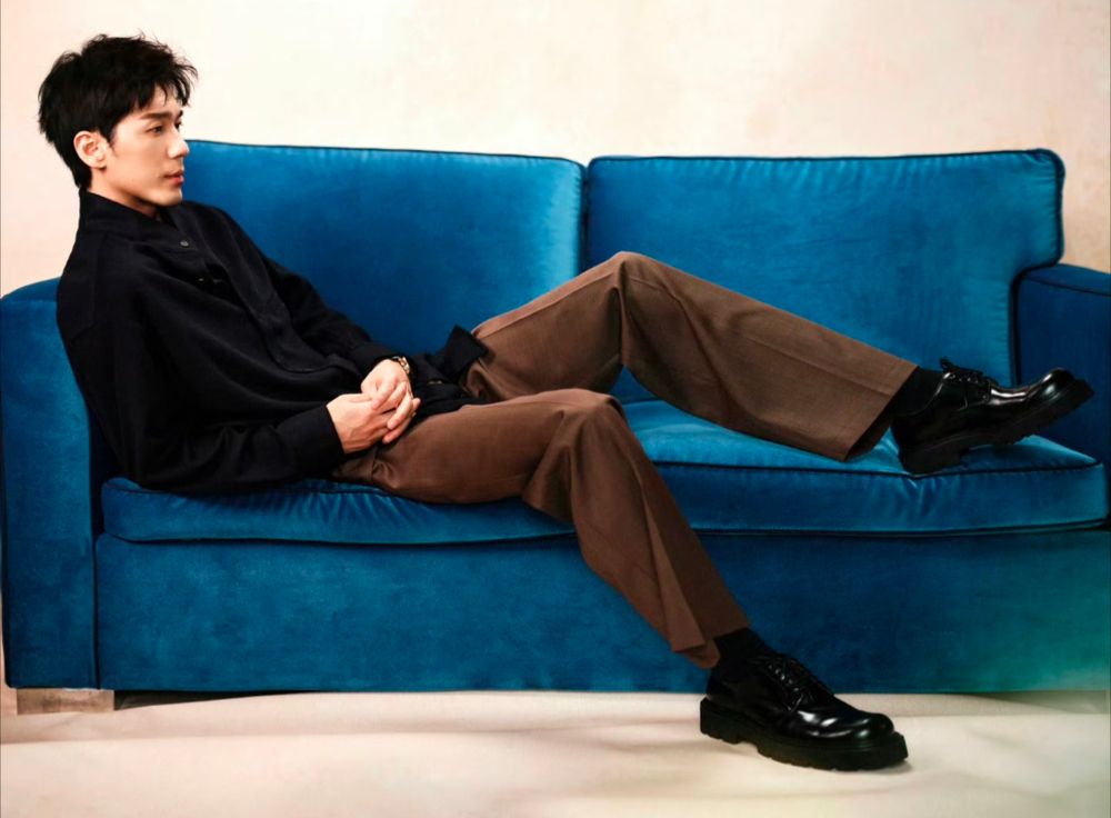 Bai Yu half lying on a blue sofa