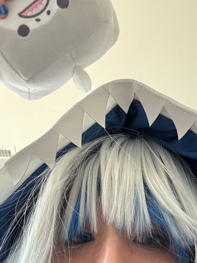 human cosplaying as gawr gura with small shark plushie :)