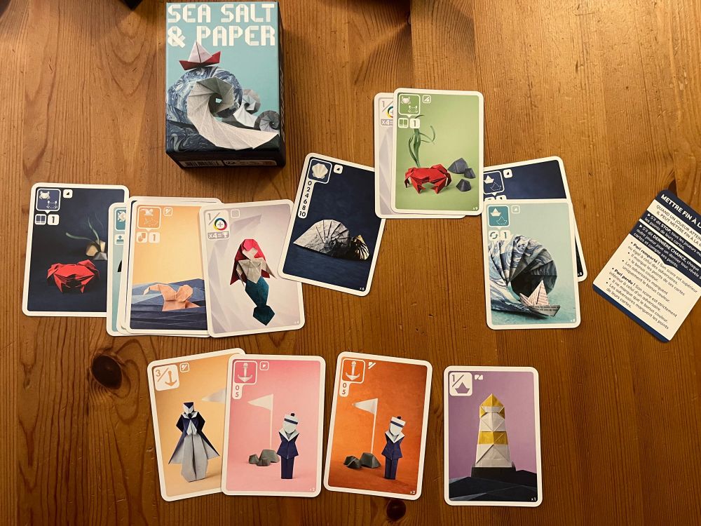 Cartes du jeu de société Sea, Salt and Paper, posées sur une table en bois.