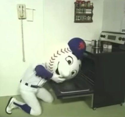 Mr Met trying to kill himself by sticking his head in an oven. Because he's a Met, nothing goes right for him and the attempt fails