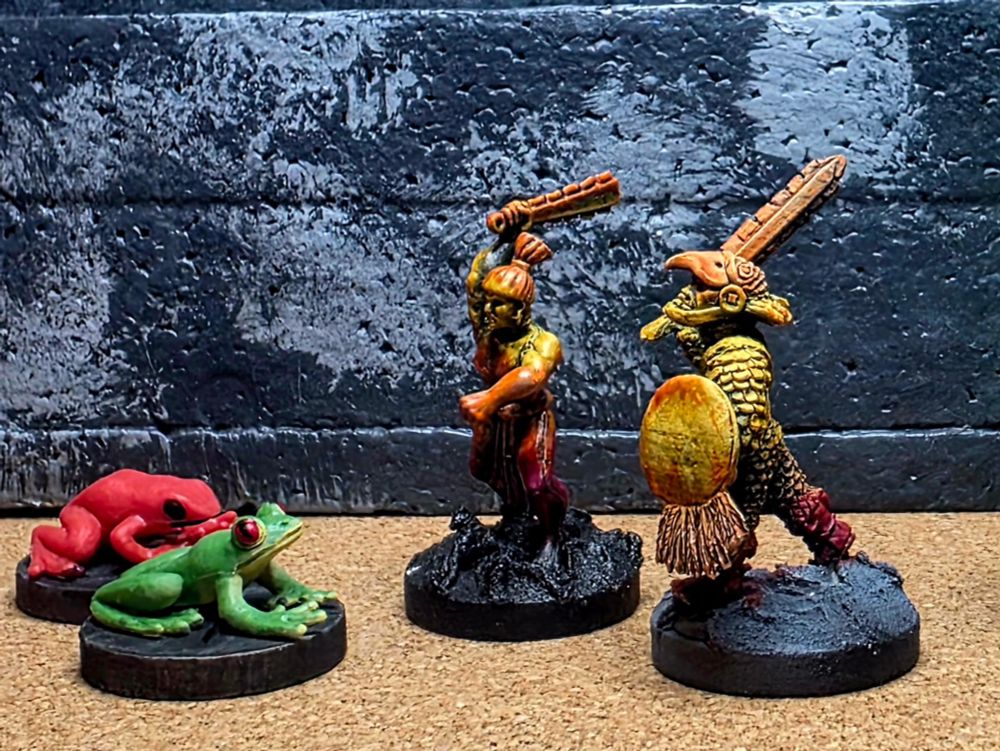 Miniatures of two mesoamerican warriors fighting frogs