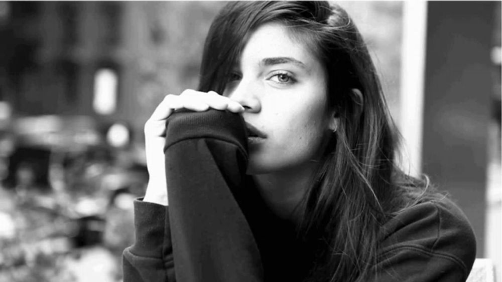 a black and white photo of a woman wearing a sweatshirt