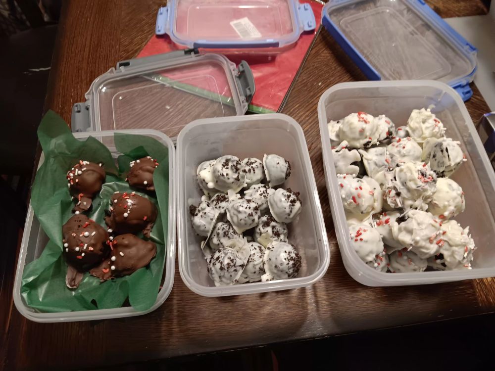 Three containers of truffles: milk chocolate peppermint oreo truffles, white chocolate oreo truffles, and white chocolate peppermint oreo truffles