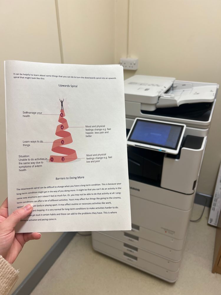 a printed worksheet is held in front of a printer