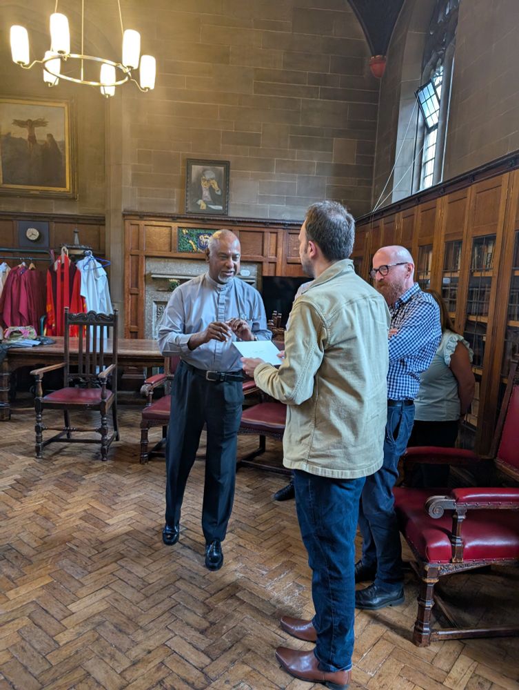 The Dean is handing Geoff a card 