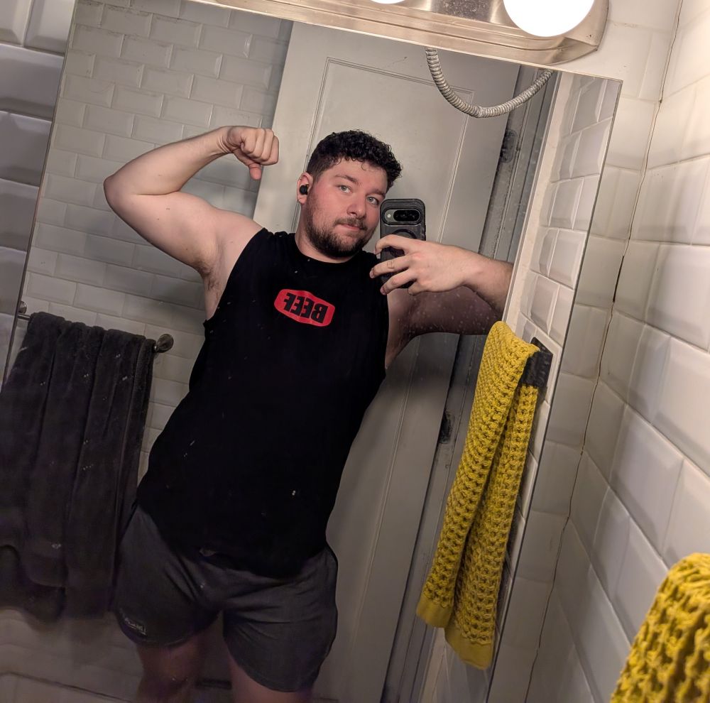 Fede in a muscle tee that says "beef' flexing