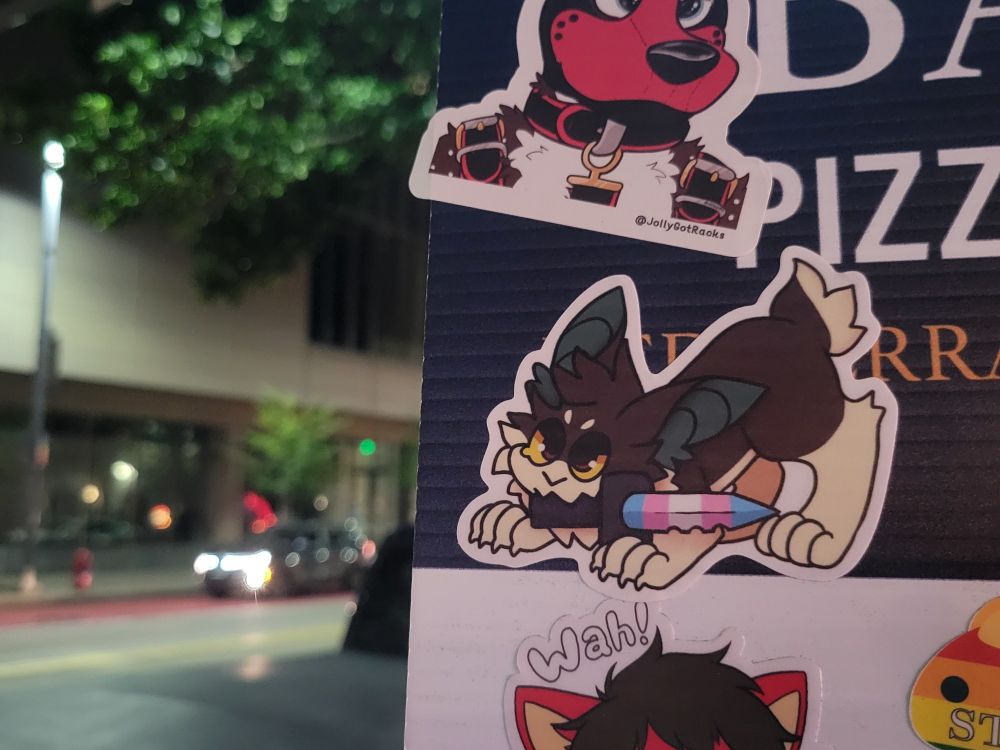 Photo of Flan's Trans Wrath sticker stuck onto a sticker board posted at Pizza Bari in Pittsburgh, PA