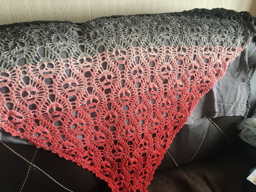 Lost Souls Skull shawl. A triangle shawl by Maryetta Roy. In a gradient of black through grey, coral, and red. Features a repeating skull motif. 

Colours symbolise the Bad Batch clone troopers from Star Wars, as requested by the commissioner. 

Cotton-acrylic. 