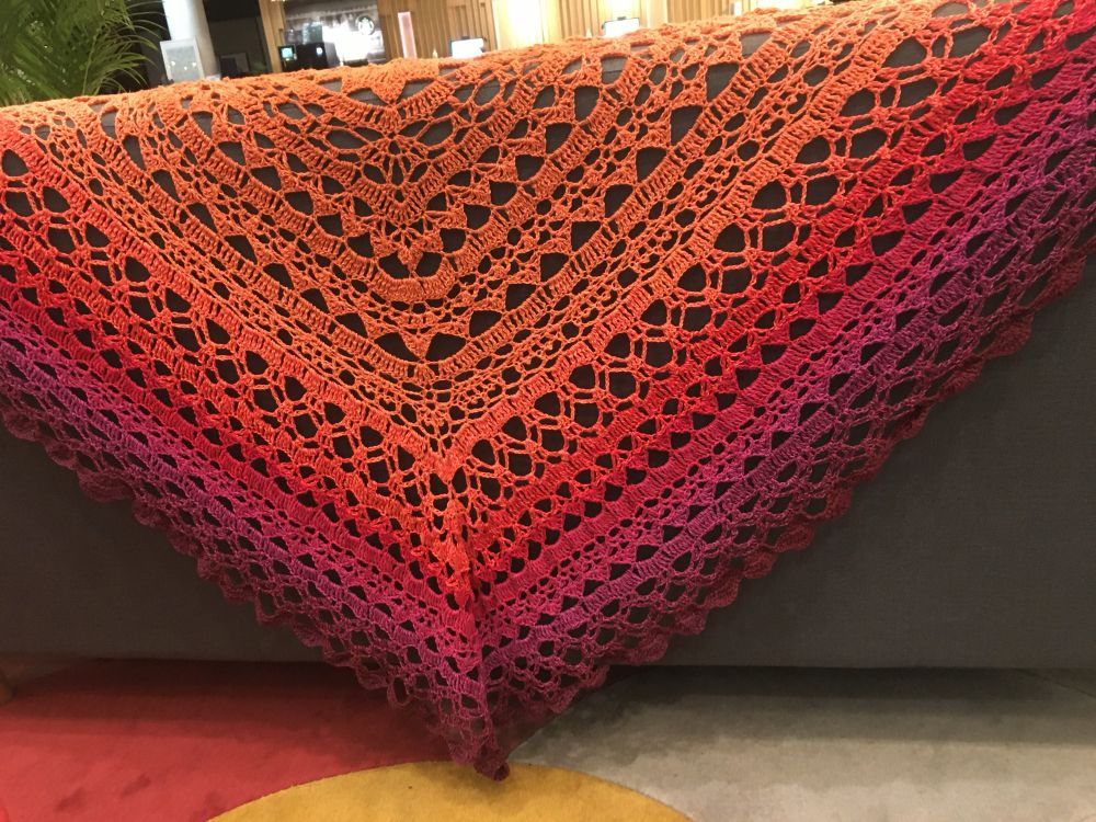 Taivas by Morben Design. A triangle shawl going through a gradient from bright orange through red, magenta and dark plum. 

Cotton-acrylic. 