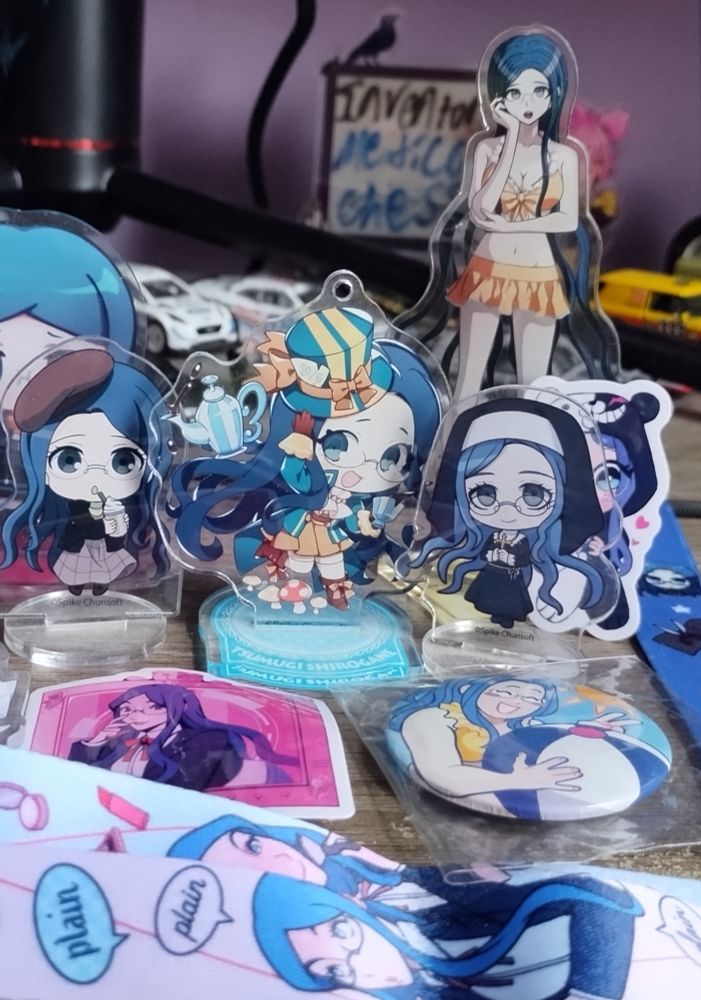 An assortment of Tsumugi Shirogane character goods are laid out on a table.