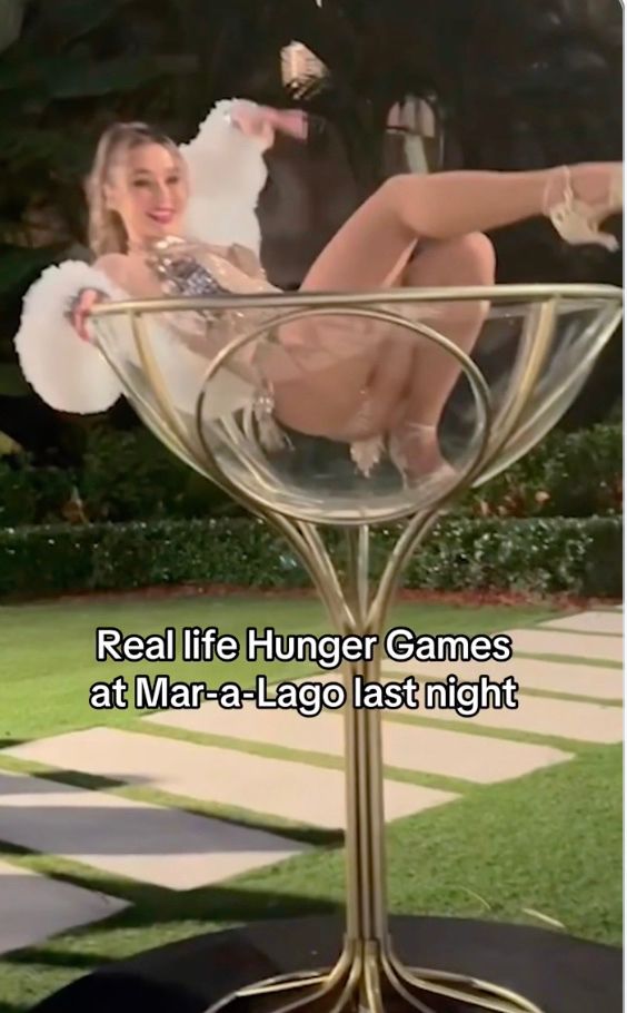 A young woman being indecently exposed while posing in a giant champagne glass.