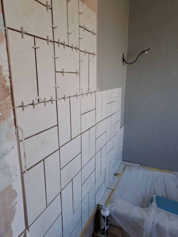A partially tiled bathroom wall