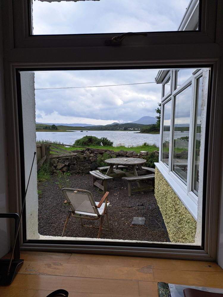 View through the front window of our holiday cottage. Loch Don, hills and clouds 