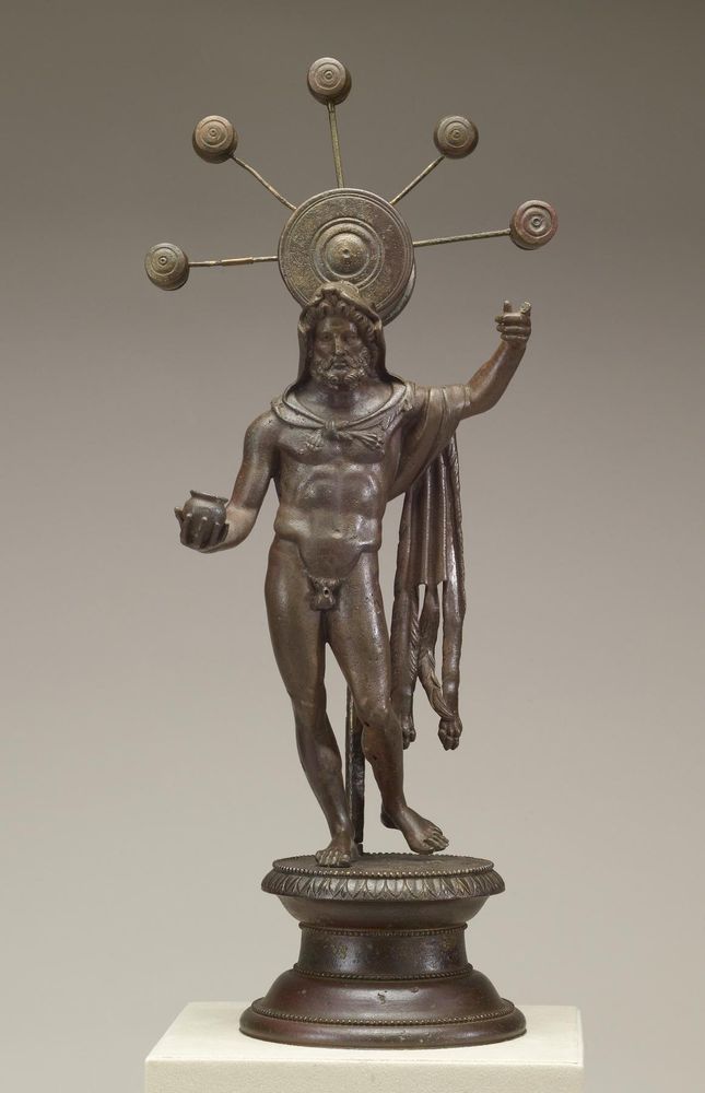 Picture from the Walters Museum of Art of their ~foot-tall bronze statue of the Celtic/Gallo-Roman deity Sucellus, standing in contraposto and holding up a mallet that has been lost to time. Floating behind him is a large mallet with five smaller mallets protruding from its head.
