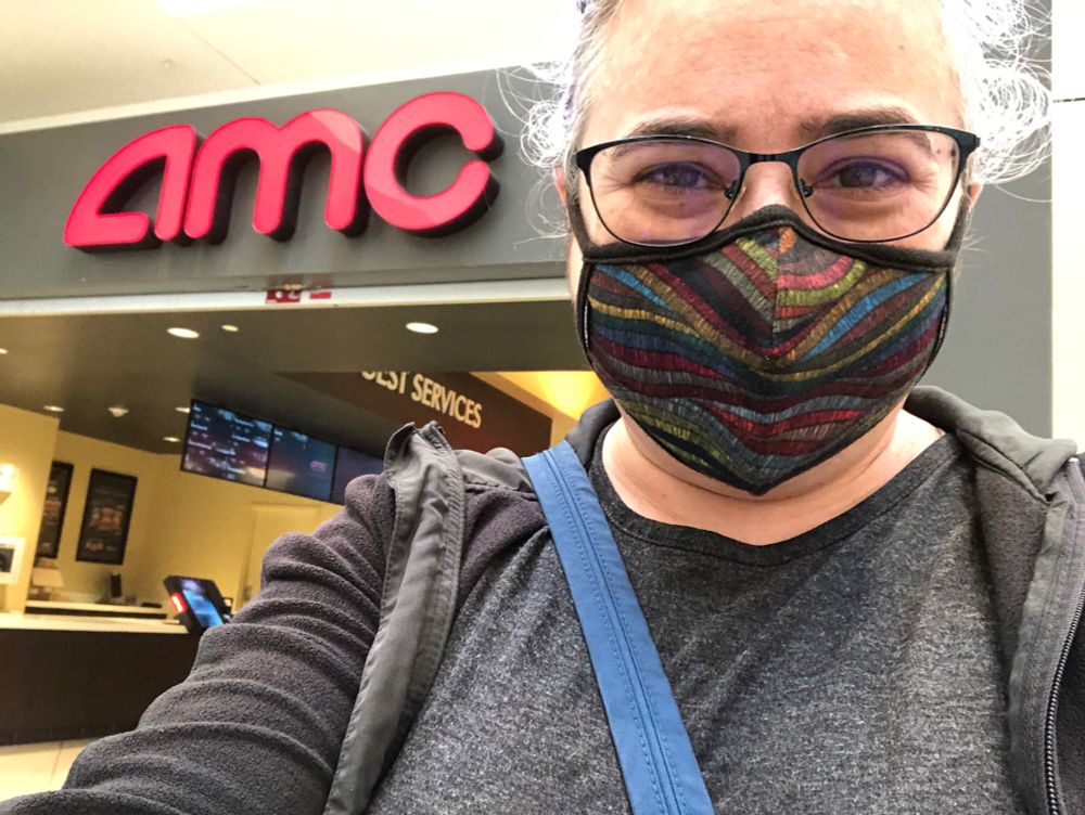 Me, masked, in front of a mall movie theater
