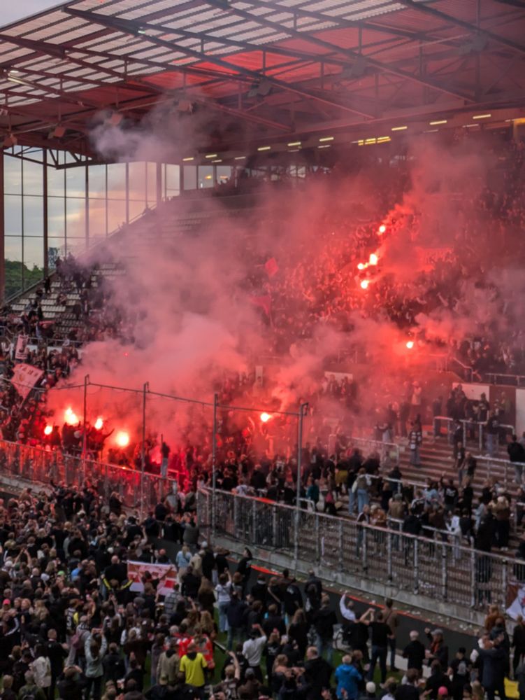 Bild der Südtribüne im Millerntor Stadion. Es wird der Klassenerhalt mit viel pyro gefeiert 