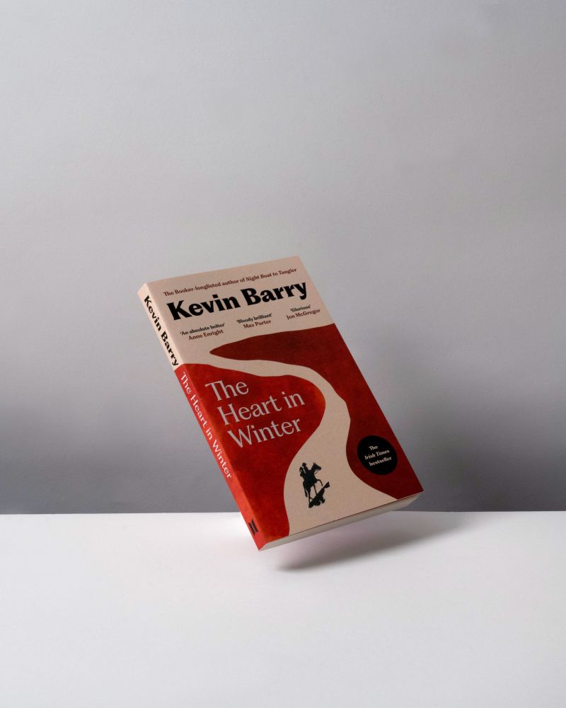 A paperback copy of The Heart in Winter by Kevin Barry, floating against a grey background