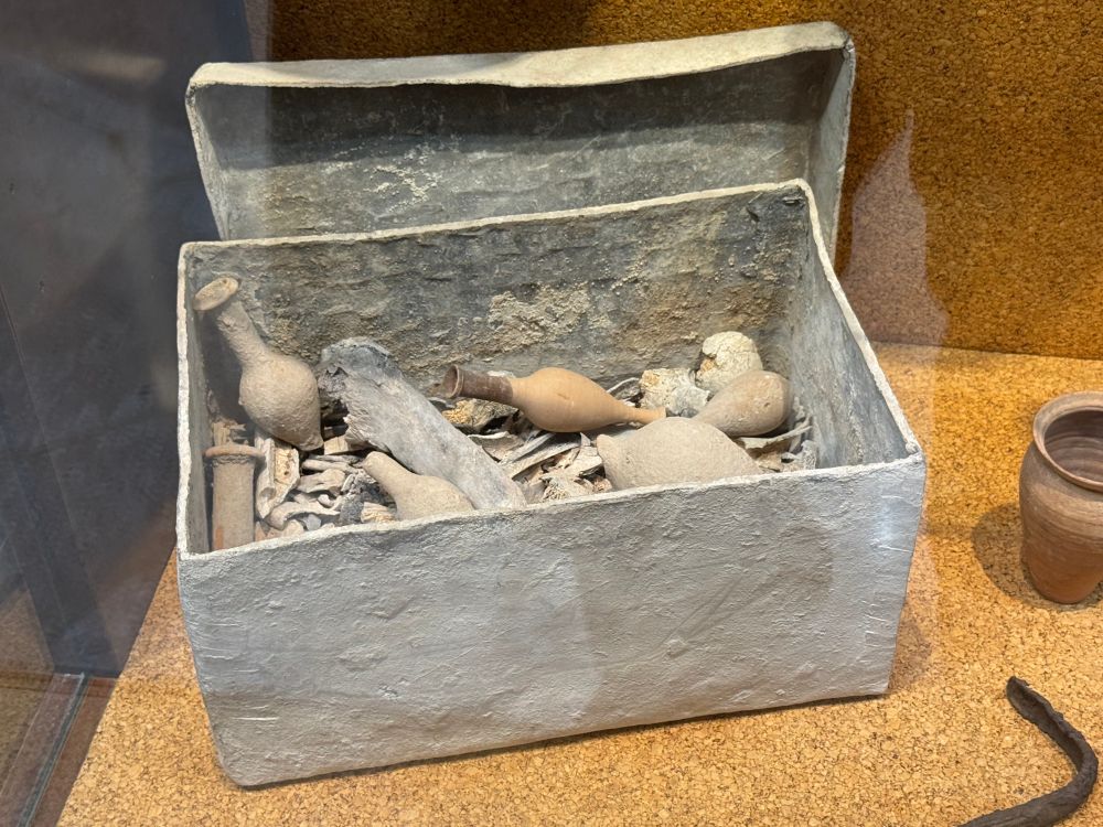 Lead burial casket filled with objects and bones.