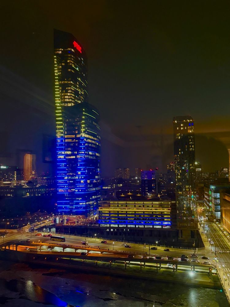 A photo of the FMC skyscraper in Philadelphia, lit up yellow and blue. 