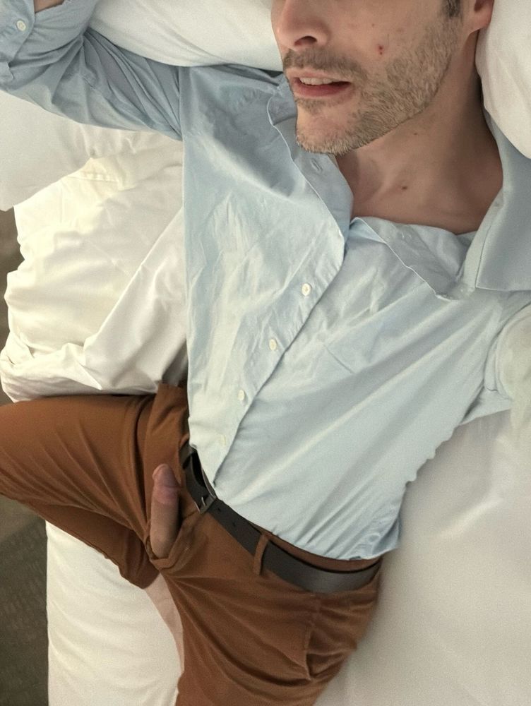 Laying on bed in business casual with exposed body 