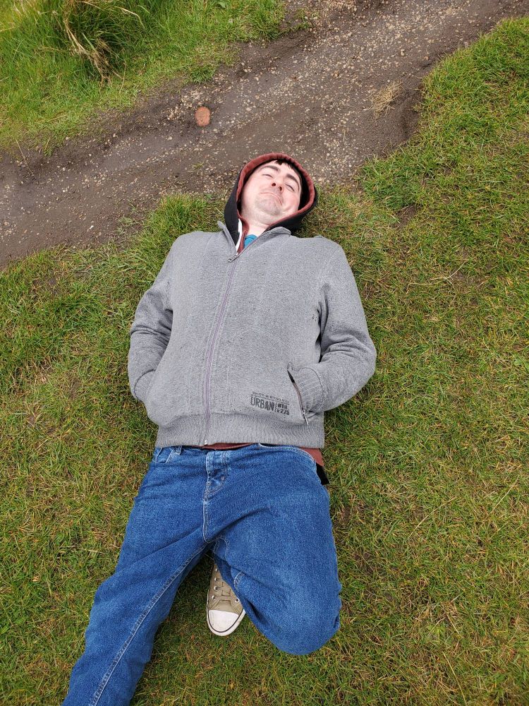 Conix laying on his back after falling in wet grass.