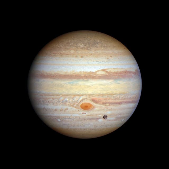 Image is of the planet Jupiter with the great red spot prominent and center. To the lower right of both Jupiter and it's spot is a much smaller moon crossing between your view - this moon is Ganymede.

Credit: NASA, European Space Agency (ESA), Space Telescope Science Institute (STScI), A. Simon (NASA-GSFC), M. H. Wong (UC Berkeley), J. DePasquale (STScI)