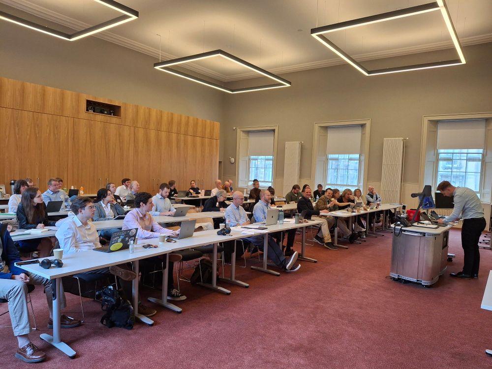 Photo of participants at conference watching Marc Geddes load his ppt